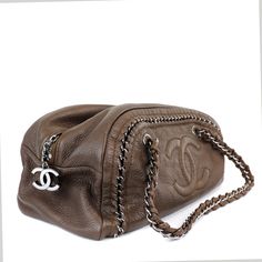 This Chanel Bronze Luxe Ligne Bowler Bag is in excellent condition from the 2006 collection. Perfectly scaled for every day enjoyment, the neutral color and exposed chain details make this Chanel a chic companion. Subtle metallic bronzy brown textured leather with silver hardware accents. Large interlocking CC is tonally stitched on the front. Exposed silver chain is uniquely woven into the design. Top zipper accesses the clean beige interior. Double straps are comfortably carried on the shoulder. Made in France. Dust bag included. Measurements: 14"x 7" x 5.5" / drop: 10" Please email for additional photos of this item. PBF 12454 Bowler Bag, Beige Interior, Brown Texture, Pretty Bags, Mode Inspo, Cute Bags, Neutral Color, Fashion Killa, Silver Hardware