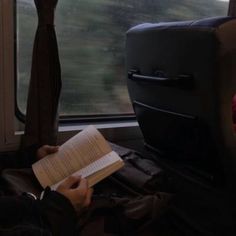 a person sitting on a train reading a book