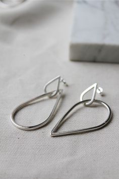 These fun teardrop hoop earrings are super easy going with a classic minimalist design that you will never get tired of.  They are striking and bold, without being over the top! -d e s c r i p t i o n- Hand drawn square wire is formed into 2 raindrops with ear pins soldered into position.  Larger drops are inter-linked and dangle freely this way and that.  So the earrings may hang in a symmetrical or asymmetrical fashion, depending how they move about during the day! The earrings come in a shiny mirror finish.  The entire drop measures 5.5cm & around 2.3cm wide, but please bear in mind, each is handmade and therefore will be unique. >All Lola&Cash jewellery will arrive gift wrapped >>Rush orders can be accommodated - please message me to discuss! Handmade Minimalist Teardrop Earrings For Everyday, Handmade Minimalist Teardrop Earrings, Minimalist Drop Hoop Earrings With Ear Wire, Minimalist Handmade Teardrop Hoop Earrings, Minimalist Handmade Long Drop Teardrop Earrings, Modern Handmade Teardrop Earrings For Everyday, Handmade Modern Teardrop Earrings, Handmade Silver Drop Earrings, Everyday Silver Minimalist Teardrop Earrings