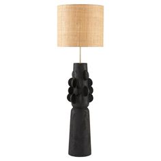 a black table lamp with a beige shade