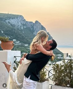 a man and woman embracing each other on a balcony