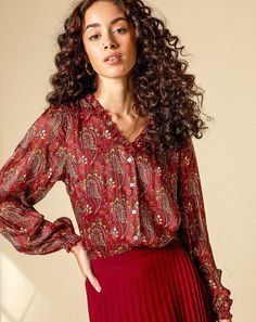 This Paisley Blouse is traced with beautiful, subtle ruffles along the V neckline which showcase just how delicate and fluttery the fabric is. Style yours with our pleated Bordo skirt to create a monochromatic look or with a pair of dark jeans. Smocked Cuffs Allover Paisley Print Fabric Contents: 100% Polyester Product Care: Dry Clean or Machine Wash (Turn inside out to prevent snags and wash in warm water). Paisley Print Fabric, Ruffle Neck Blouse, Dark Jeans, V Neckline, Paisley Print, Red Leather Jacket, Smocking, Ruffles, Bell Sleeve Top