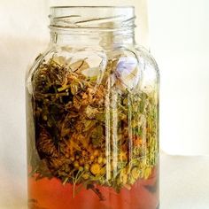 a glass jar filled with lots of different types of flowers and plants inside of it