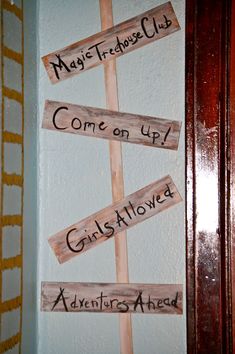 wooden signs are hanging on the wall in front of a door that says, may's tree club come on up girlstown adventures ahead