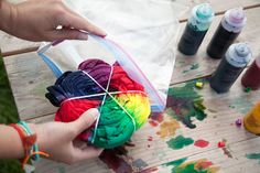 someone is painting on the table with different colors and supplies to make it look like they're doing something