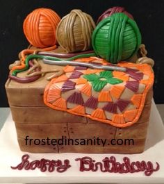 a birthday cake with yarn and balls on it