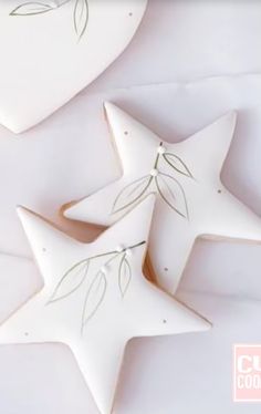 two white ceramic stars with green leaves on them