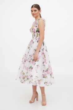 This tie-strap midi dress is made in a floral print. The dress is designed with a flaring skirt, which has a full-length lining. The corset features a heart-shaped neckline and tie-straps with lace-up closure. DETAILS Material: Tulle Fabric Composition: 100% polyester Sleeves style: Tie straps Silhouette: A-line Skirt length from waist: 90 cm Neckline: Heart-shaped neckline Back: Lace-up corset Built-in cups Lining: White full-length A-line underskirt Art. N: Milla800-10 Apple Blossom Milla Dresses, Tie Strap Dress, Sleeves Style, Wedding Attire Guest, Apple Blossom, Tulle Fabric, Wedding Attire, Strap Dress, A Line Skirt