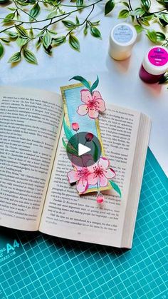 an open book sitting on top of a table next to some scissors and glues