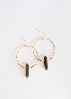 Smoky Quartz is known for its grounding, balancing, and protective vibrations. It works to ground the wearer back into the earth while promoting heart-opening energies.These double pointed crystal earrings are handcrafted out of 18kt gold over sterling silver.Each polished gemstone is roughly 1" x 0.25" wide - as with natural stones, each will vary in color and size. Hoop measures 1.5" in diameter. Quartz Hoop Earrings, Smoky Quartz Earrings, Smoky Quartz Crystal, Crystal Hoop Earrings, Quartz Earrings, Smokey Quartz, Smoky Quartz, Delicate Bracelet, Crystal Earrings