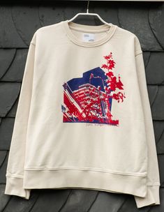 A brutalist sweatshirt in size L. The color is cream white. The University of Siegen is printed on the front. The sweatshirt is also printed on the back. The print colors are dark blue and red. Made with love for architecture. Unique piece. 100% organic cotton recycled, upcycled, second hand; SCREEN PRINTING, ART Cream Crew Neck Top With Graphic Print, Urban Cotton Sweatshirt With Screen Print, Urban Cotton Sweatshirt With Graphic Design, Cream Sweatshirt With Embroidered Logo For Streetwear, Cream Sweatshirt With Logo For Streetwear, Cream Crew Neck Sweatshirt With Graphic Print, Cream Cotton Sweatshirt With Graphic Print, Beige Crew Neck Sweatshirt With Graphic Print, Urban Beige Sweatshirt For Streetwear