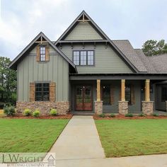 a gray house with brown shutters and green grass