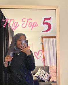 a woman taking a selfie in front of a mirror with the number 5 on it