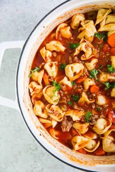 a pot filled with pasta and meat soup