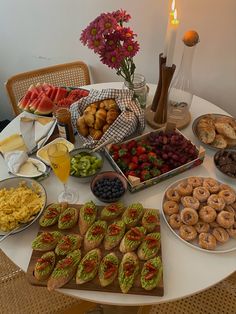 a table filled with assorted food and drinks on it's side, including donuts