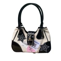 a white and black handbag with stars on the front, two tone leather handles