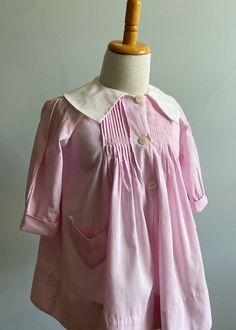 "I have had this pretty smock dress for some time now. It was purchased in Paris and needed extensive work at neckline/collar. The entire neckline was covered in vintage seam binding and an entirely new collar was made, based on the original design. It dates from the 1930's and is a gorgeous piece.                    Made of a finely woven rose pink cotton, the front bodice features ten pleats on either side of center front.  These are secured with a delicate pink and white hand embroidered band Linen Pinafore Dress, Seersucker Jacket, Linen Pinafore, 1960 Dress, Girls Smocked Dresses, Vintage Girls Dresses, Girls Smock, Vintage Dresses 1960s, Seam Binding