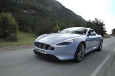 a silver sports car driving down the road