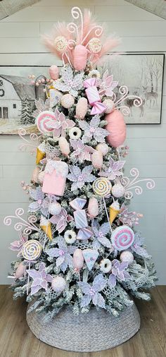 a pink and white christmas tree decorated with lollipops