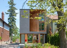 the house is surrounded by trees, grass and brick buildings with large windows on each side