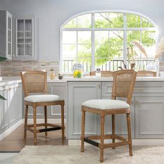 two wicker bar stools in front of a kitchen window