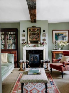 a living room filled with furniture and a fire place next to a bookcase full of books