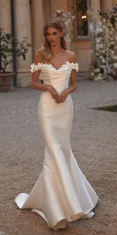 a woman in a white dress standing outside