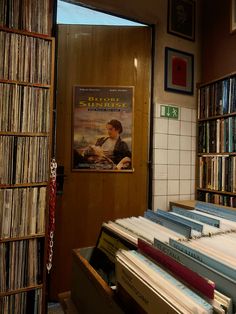 there are many records on the shelves in this room and one has a poster above it