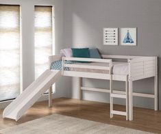 a white bunk bed with a slide in front of it