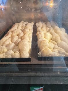 two trays of bread sitting on top of a conveyor belt