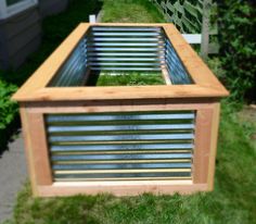 a wooden box with metal slats on the sides and grass growing in between it