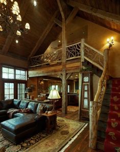 a living room with couches, rugs and stairs leading to the second floor