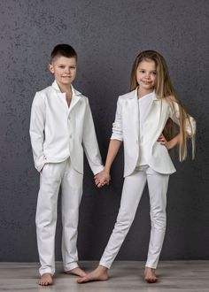 two children dressed in white standing next to each other