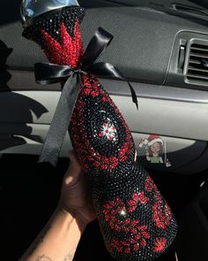 a hand holding a red and black car decoration