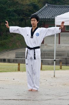 a man standing on top of a cement ground holding his arms out in the air