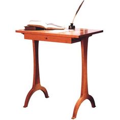 a wooden desk with a lamp on top of it and a book in front of it