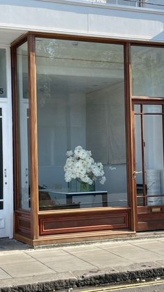 there is a vase with flowers in it sitting on the window sill at this store