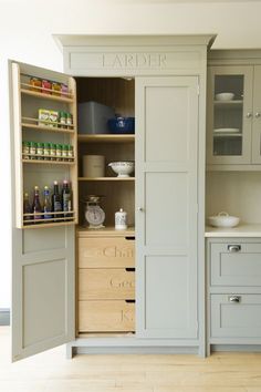 an open cabinet in the middle of a kitchen with lots of drawers and cupboards