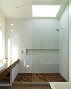 an empty bathroom with a skylight above the bathtub and shower stall in it