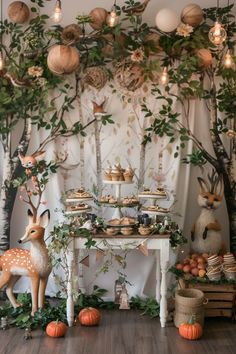 the dessert table is set up with deer figurines and pumpkins on it