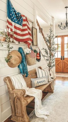 a wooden bench sitting in the middle of a living room next to a flag and wreath