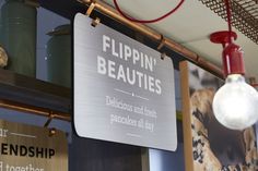 there is a sign that says flippin'beauties in english and spanish on the wall