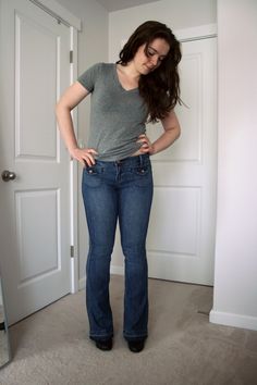 a woman standing in front of a door with her hands on her hips