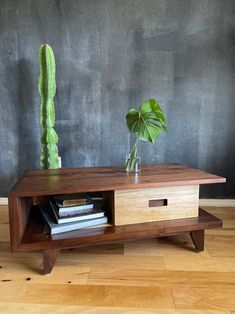 a wooden table with a plant and books on it