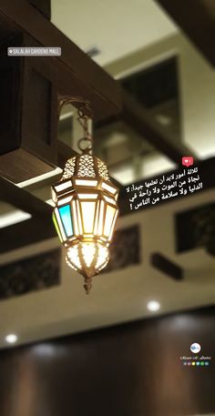 a light hanging from the ceiling in a room with arabic writing on it and an image of