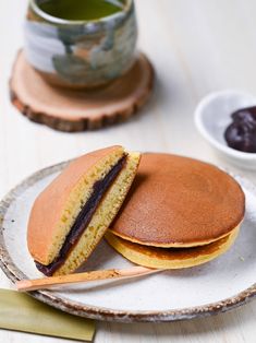 there is a plate with two pancakes on it and a cup of tea in the background