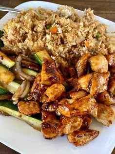 a white plate topped with chicken and veggies next to rice