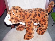 a stuffed animal that is laying down on a chair