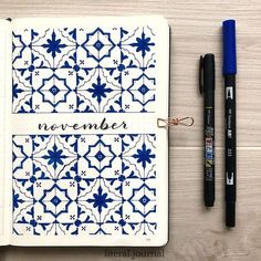 an open notebook with the words november written on it and two pens next to it