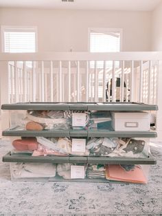 there is a large stack of items on the floor in front of a baby crib